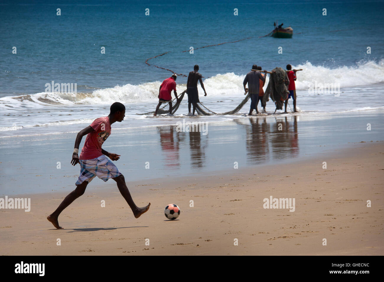 Freetown, Sierra Leone - 8. Juni 2013: die Strände des Stadtteils Aberdeen, junge spielt Fotoobal im Hintergrund der fisherme Stockfoto