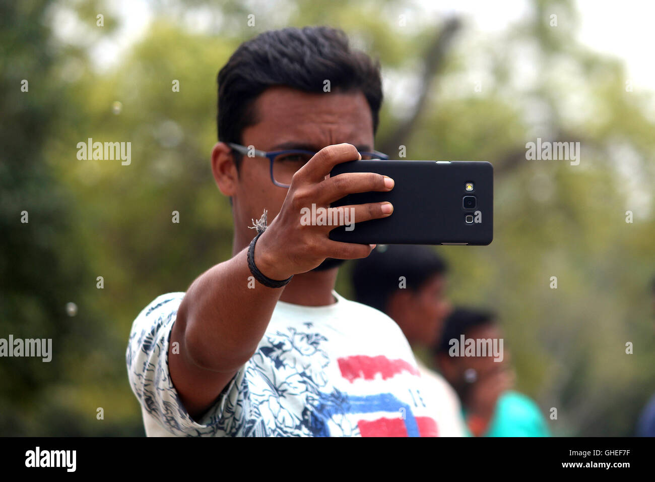 Ein junger indischer Mann ein Foto mit seinem Handy. Stockfoto