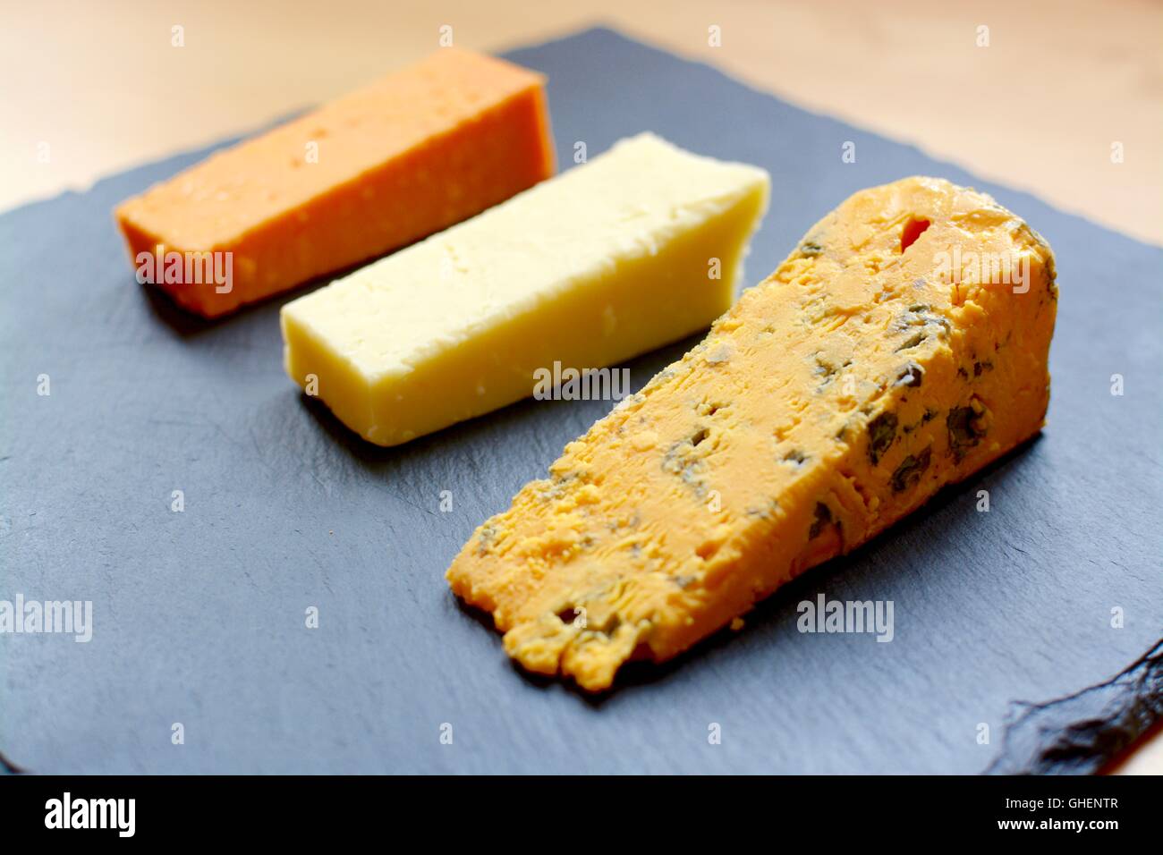 Drei Käse Auswahl auf schwarzem Schiefer serviert. Stockfoto