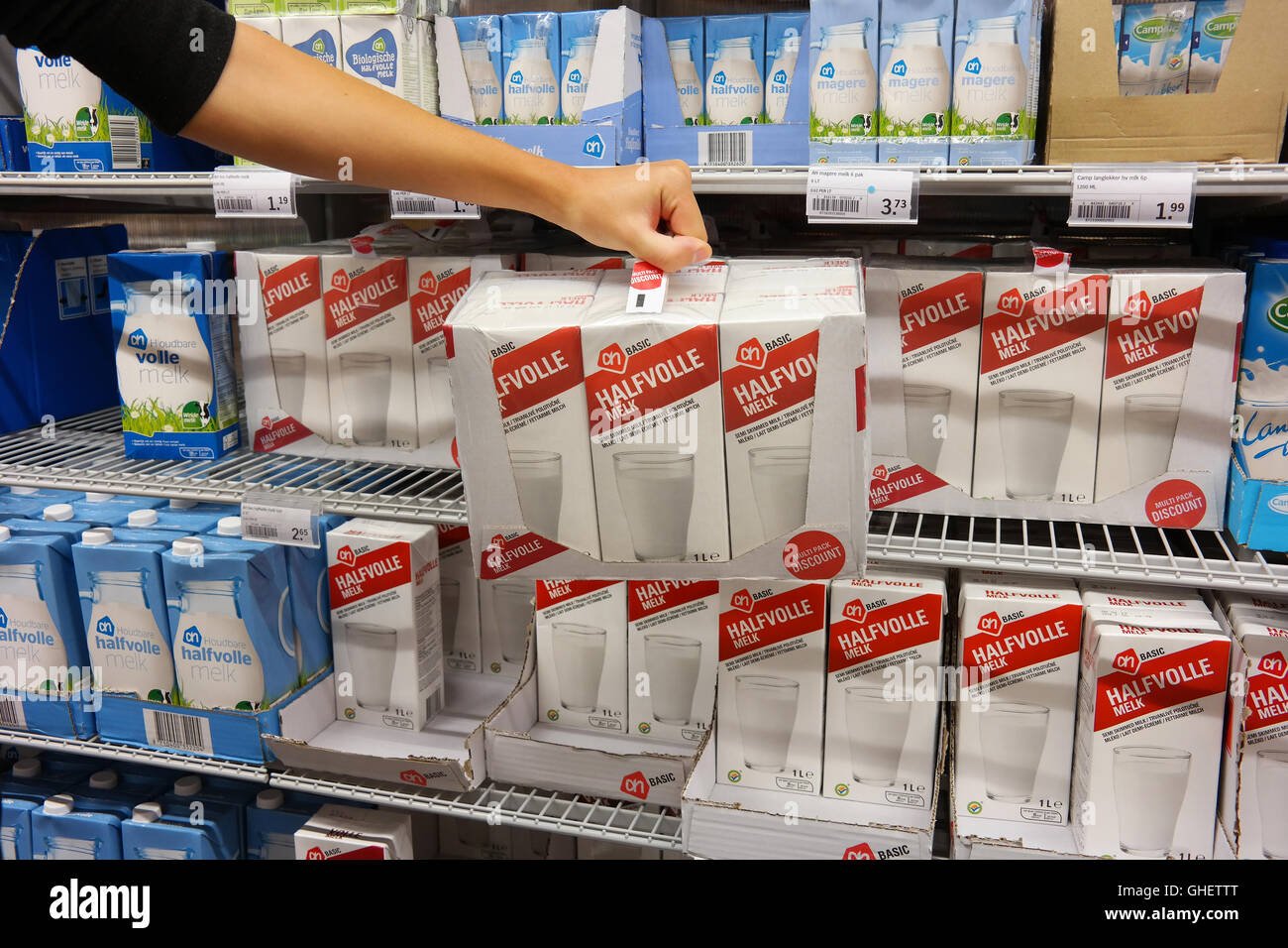Kunde nimmt Sixpack Milch im Supermarkt. Stockfoto