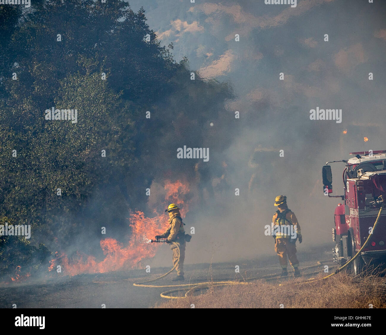 Mokassin, Kalifornien, USA. 27. Sep, 2016. 27. September übergießen 2016.CalFire Feuerwehrleute Flammen aus einem Sümpfe Feuer Backburn entlang Highway 49 zwischen der Mokassin-Kraftwerk in Mokassin und Coulterville, Kalifornien. Das Feuer ist etwa 1.000 Hektar und 25 % enthalten. Bildnachweis: Tracy Barbutes/ZUMA Draht/Alamy Live-Nachrichten Stockfoto