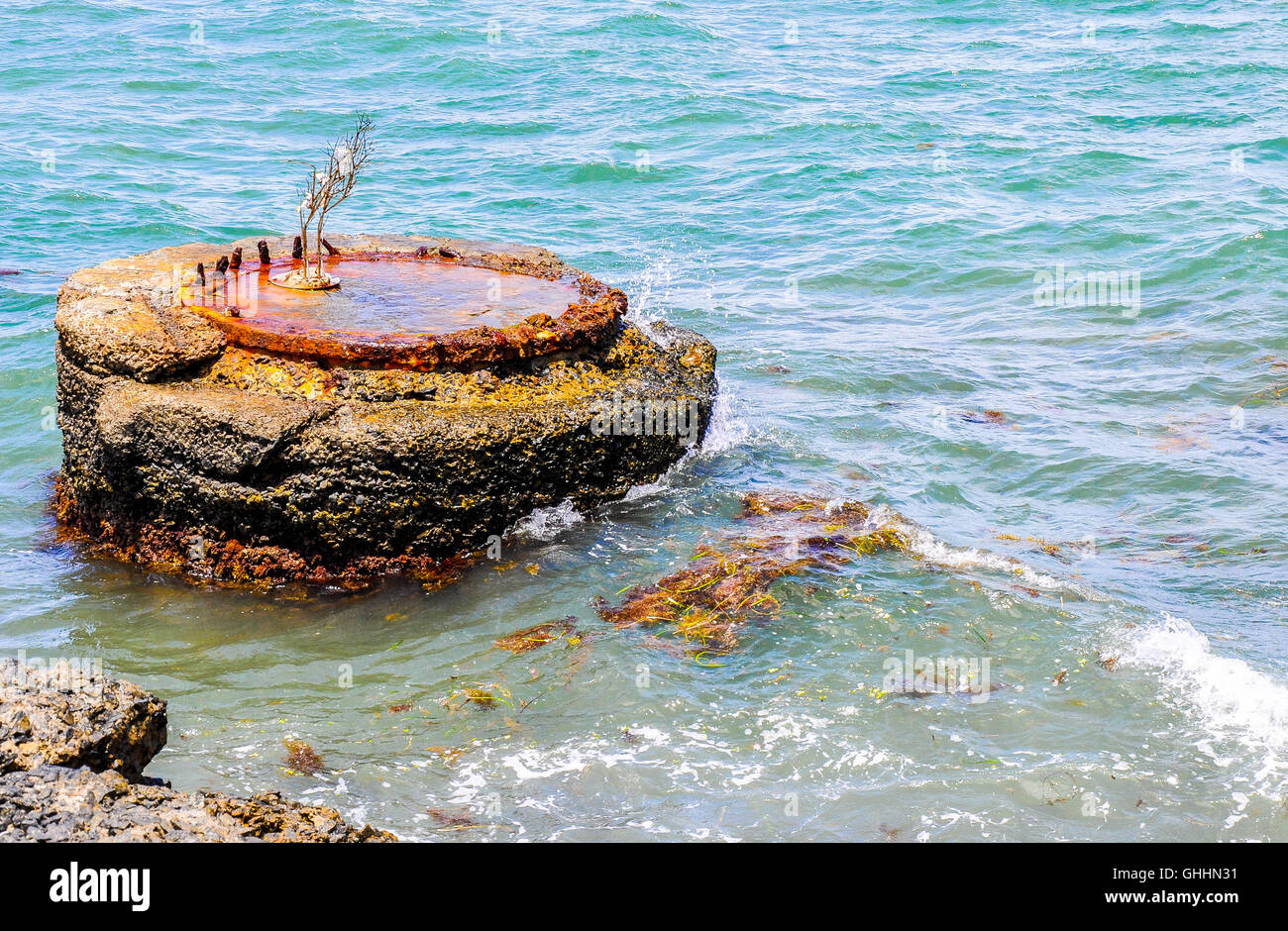 Konkrete Boje mit rostigem Metall Scheibe an der Spitze in das türkisfarbene Wasser des Indischen Ozeans in Fremantle, Western Australia. Stockfoto