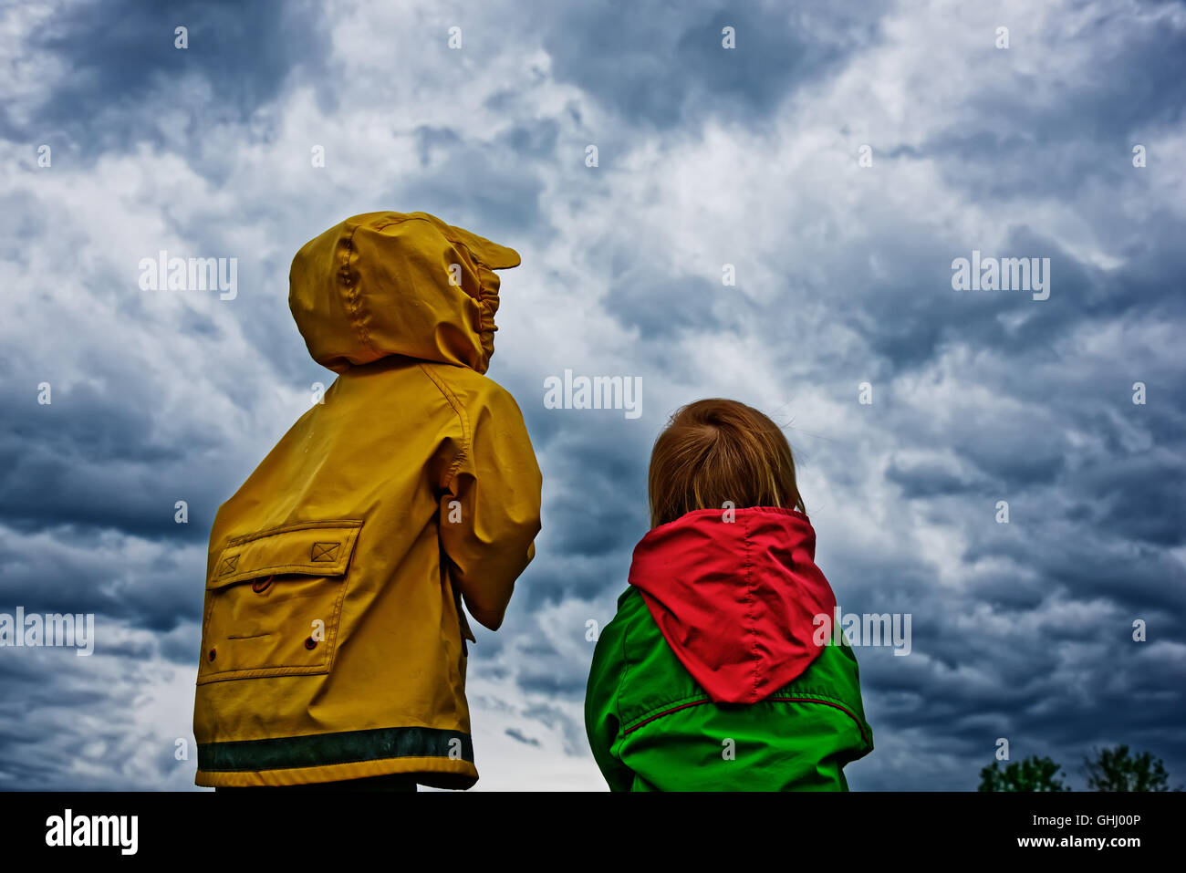 Zwei Kinder Stand zusammen mit Blick sehnsüchtig auf ein Sturm zieht auf Stockfoto