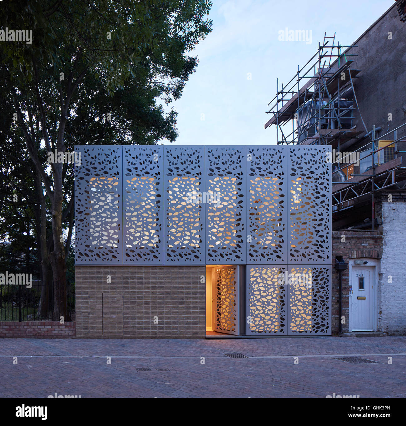 Vordere Ansicht in der Abenddämmerung mit offenen Eingangstür. Haus in Brixton, London, Vereinigtes Königreich. Architekt: Horden Cherry Lee Architects Ltd, 2016. Stockfoto