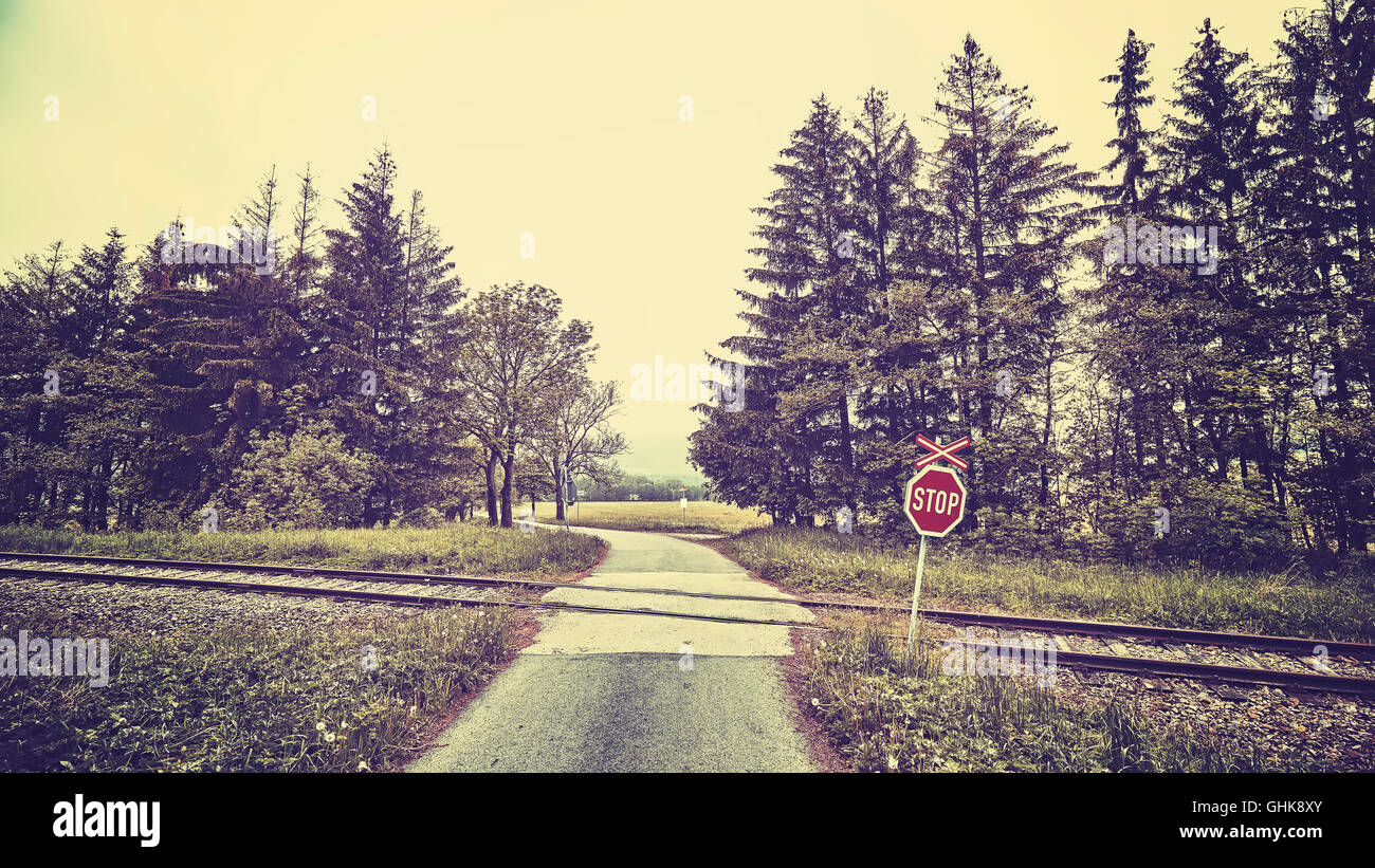 Vintage getönten Stop-Schild am Bahnübergang in einer ländlichen Landschaft. Stockfoto