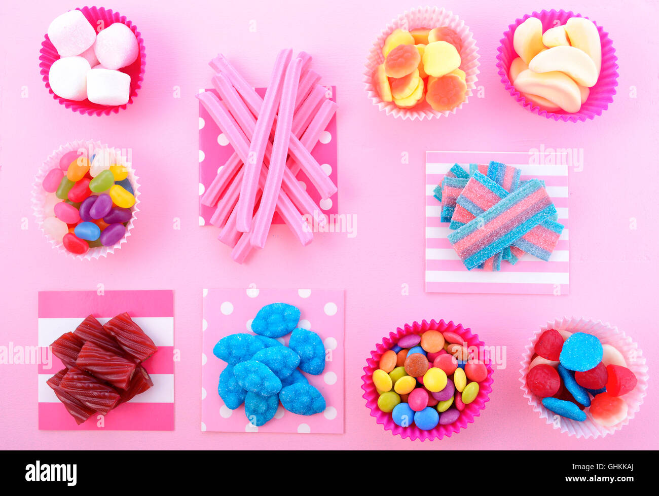 Hellen bunten Süßigkeiten Hintergrund auf rosa Holztisch für Halloween Trick behandeln oder Kinder Geburtstag party Gefälligkeiten. Stockfoto