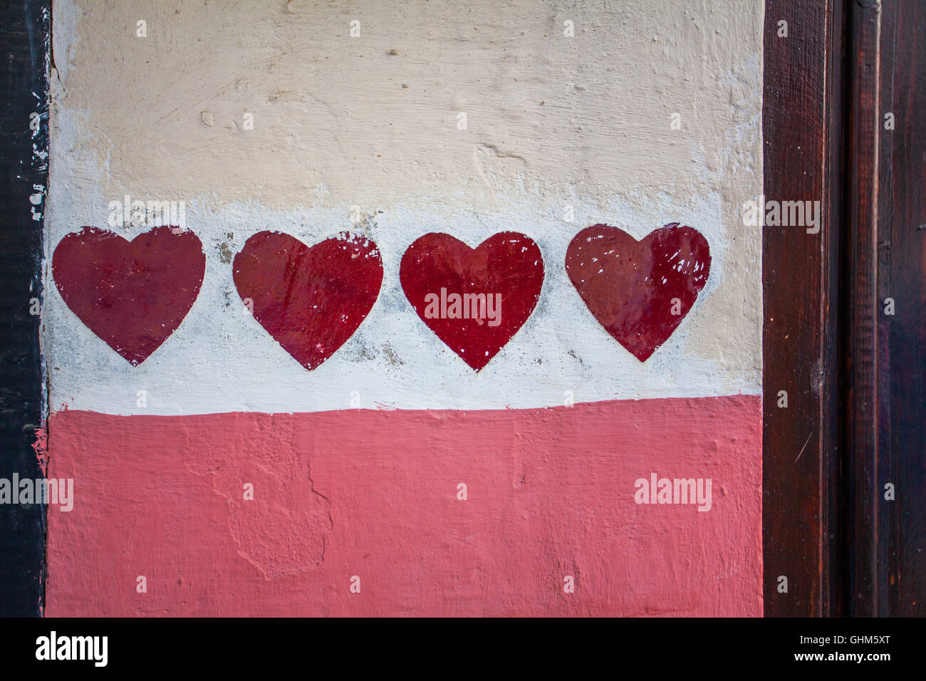 Rote Herzen auf eine bunte Wand Hintergrund gemalt Stockfoto