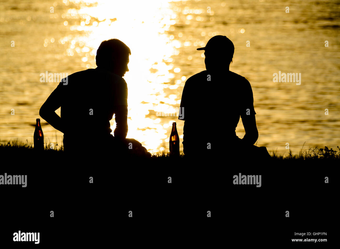 2 junge Teenager Teenager Biertrinker entlang der Donau, untergehende Sonne, Österreich, Stockfoto