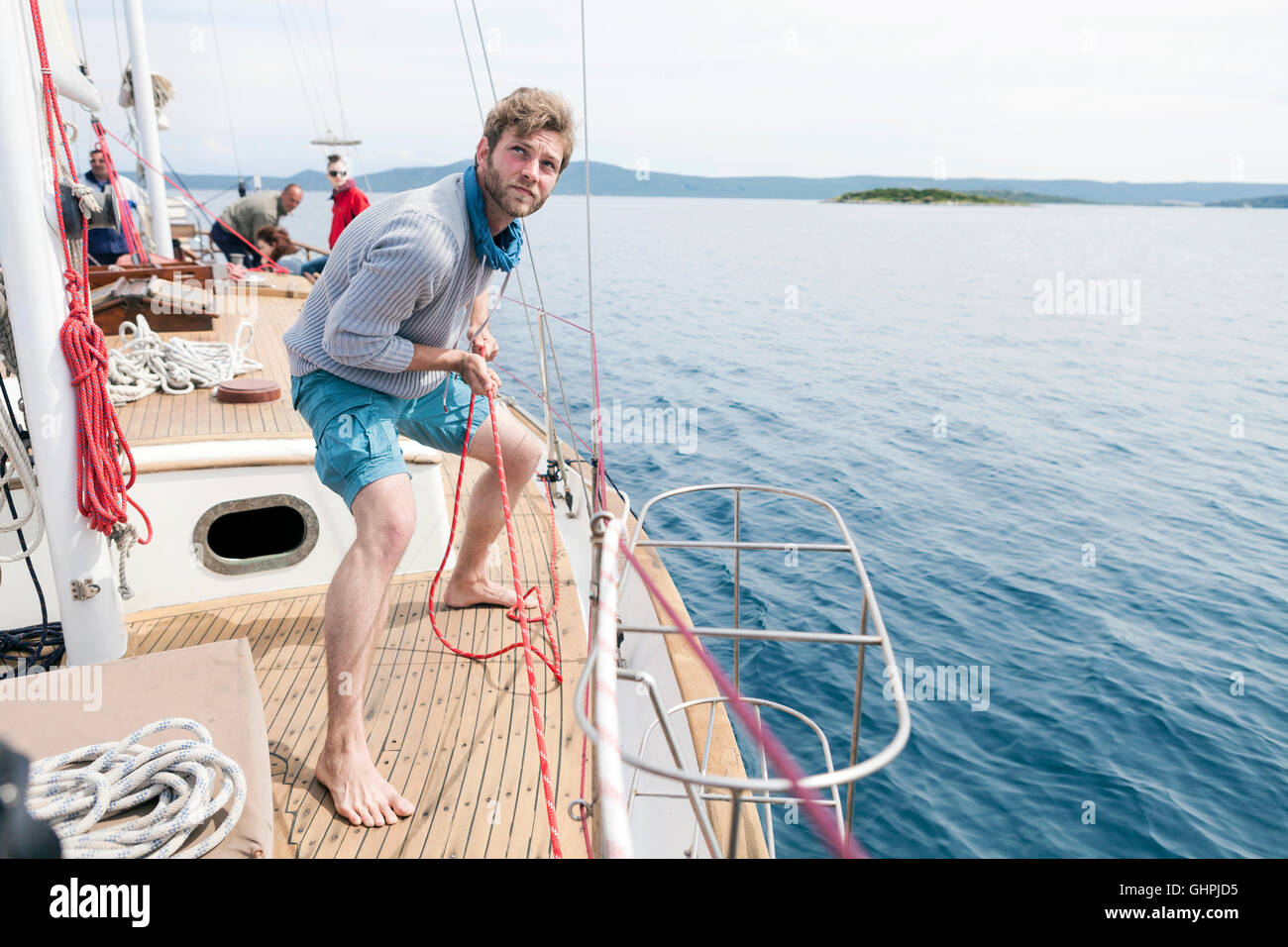 Man zieht am Seil auf yacht Stockfoto