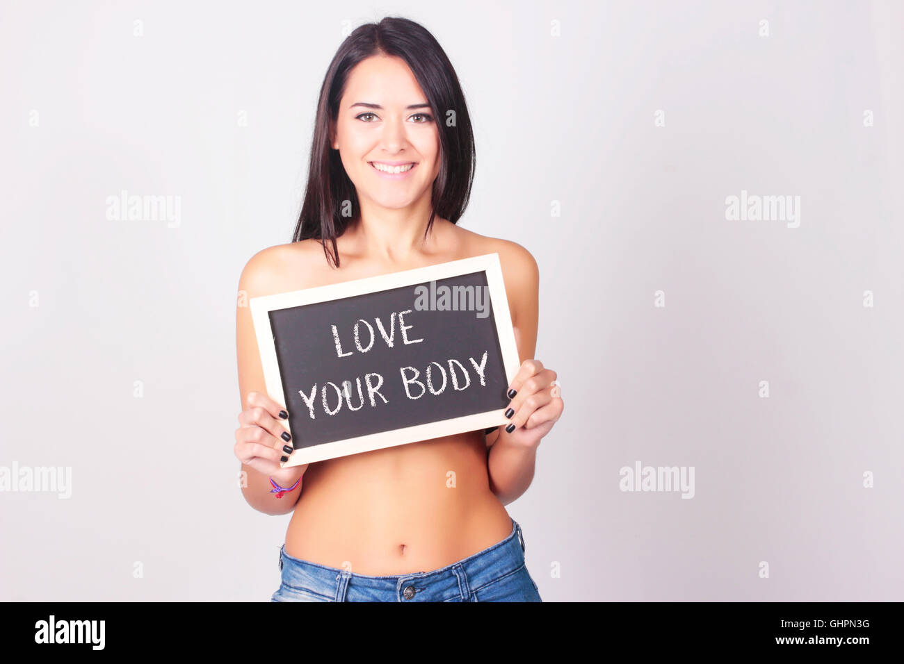 Junge Frau mit Tafel, die Love Your Body liest. Selbstliebe-Konzept. Stockfoto