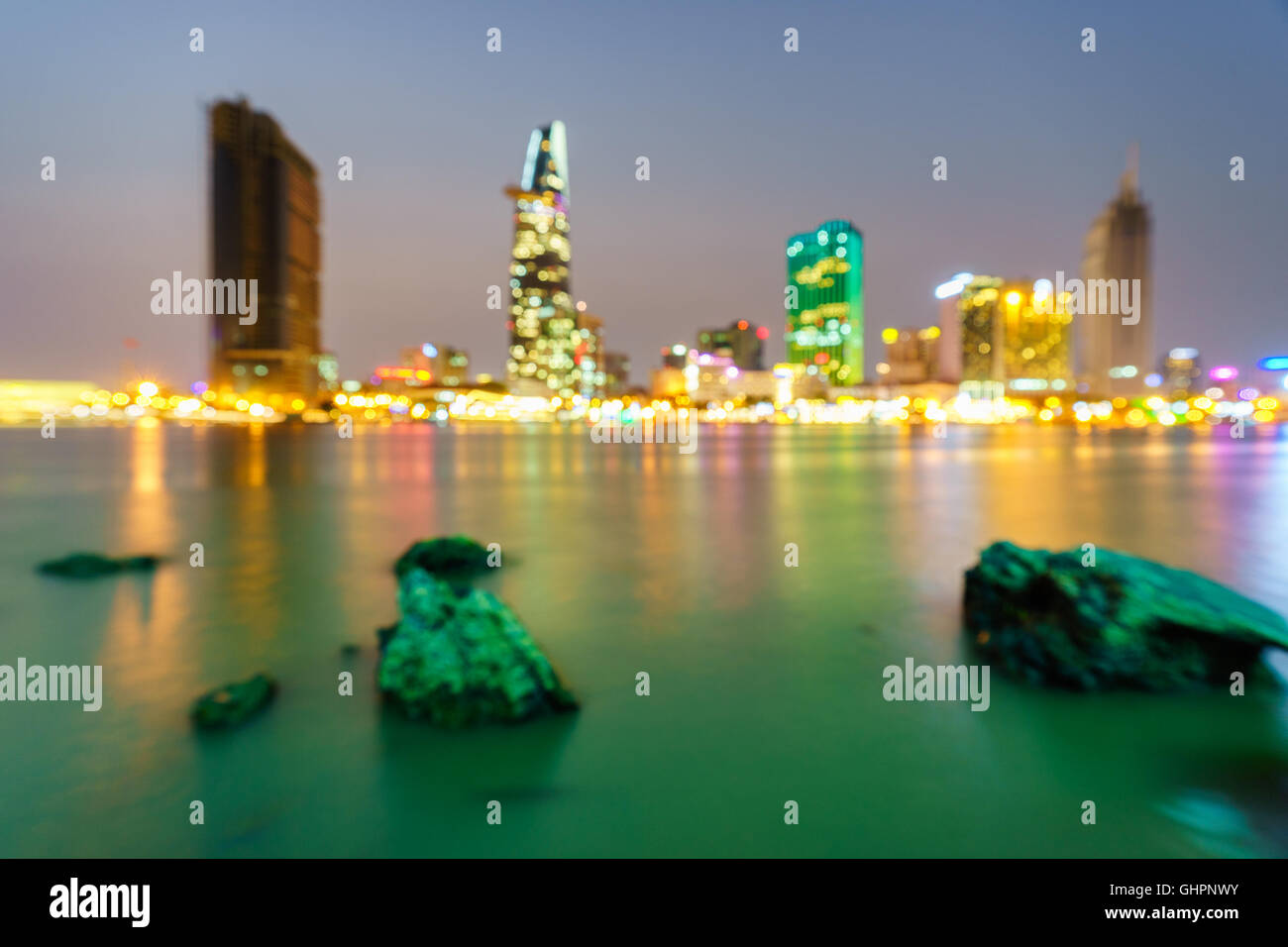 Ho-Chi-Minh-Stadt Skyline und den Saigon River in der Dämmerung mit defokussierten Bokeh Lichter als abstrakten Hintergrund, Vietnam. Stockfoto