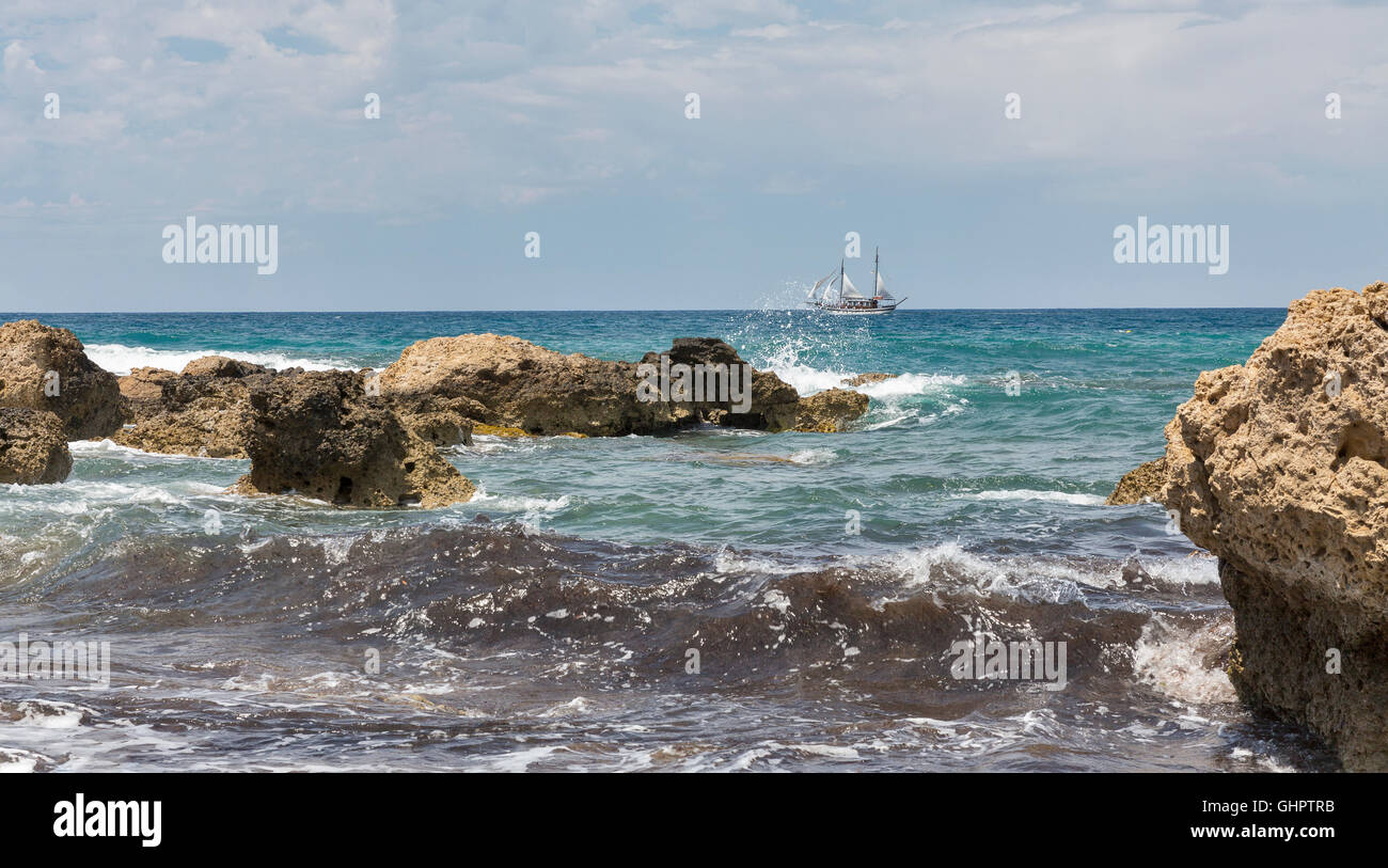 Seelandschaft mit Segelschiff und Steinen. Paphos, Zypern. Stockfoto