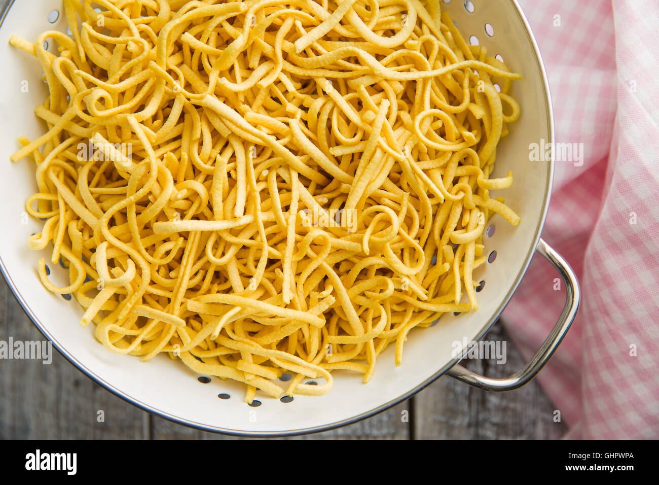 Leckere Spätzle-Nudeln im Sieb. Stockfoto