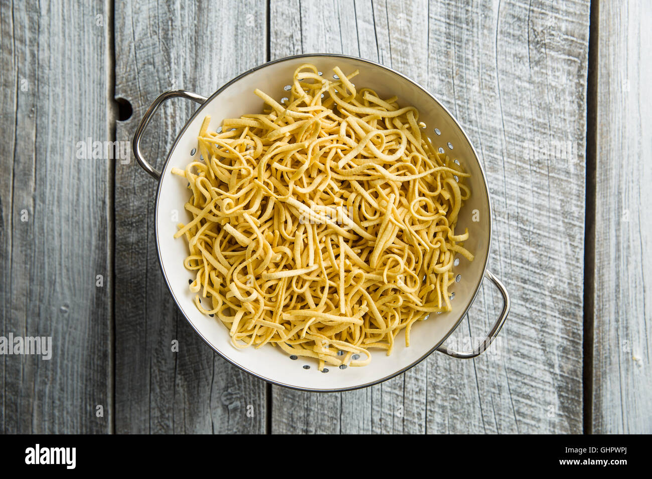 Leckere Spätzle-Nudeln im Sieb. Stockfoto