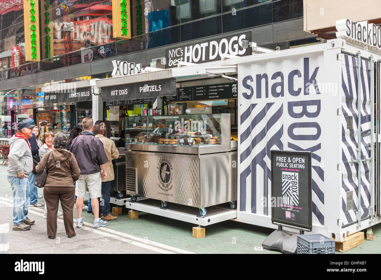 People stand in line to make a purchase at the Snack Box, a food and beverage kiosk, in Times Square in New York City. Stockfoto
