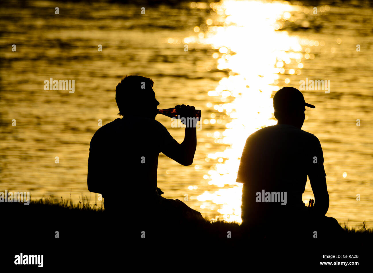 2 junge Teenager Teenager Biertrinker entlang der Donau, untergehende Sonne, Österreich, Stockfoto