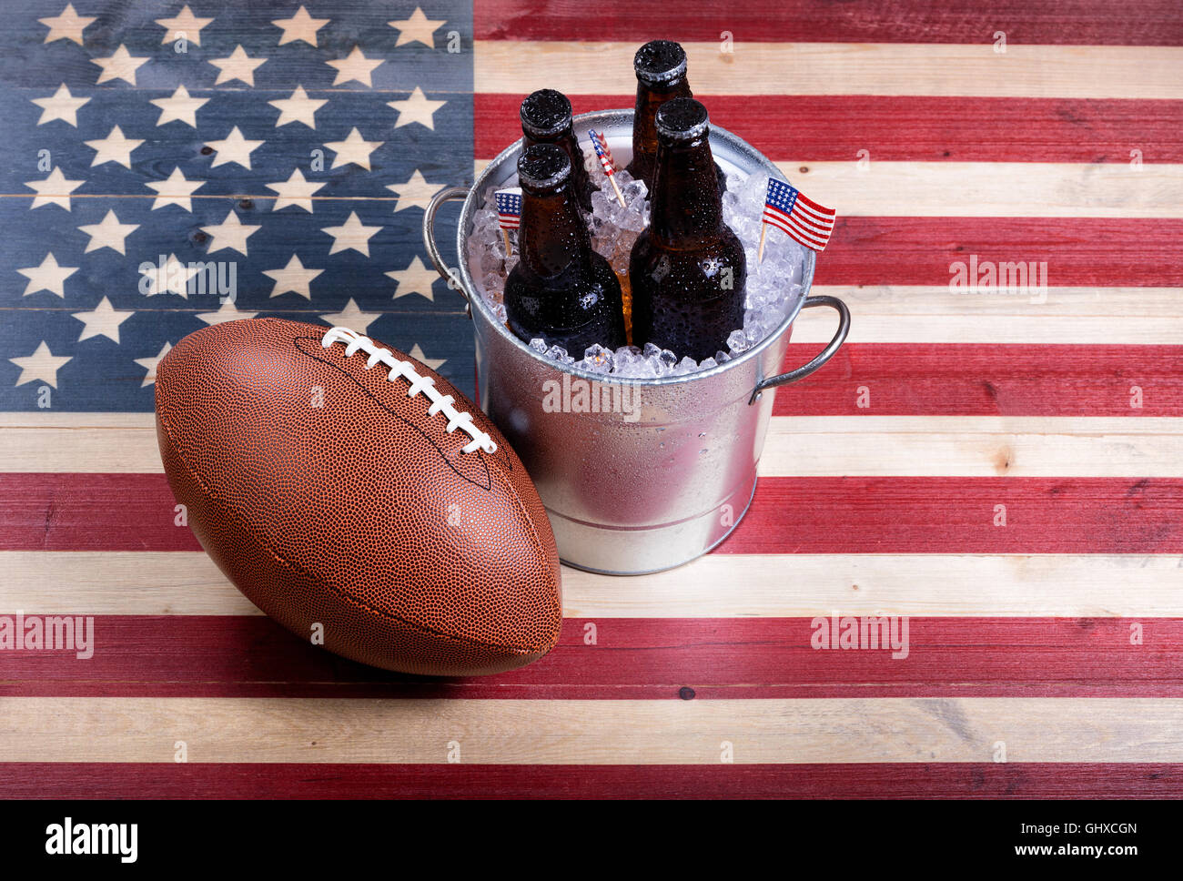 Draufsicht des American Football und Eimer eiskalten Bier auf urigen Holzbrettern mit bemalten USA-Flagge. Stockfoto