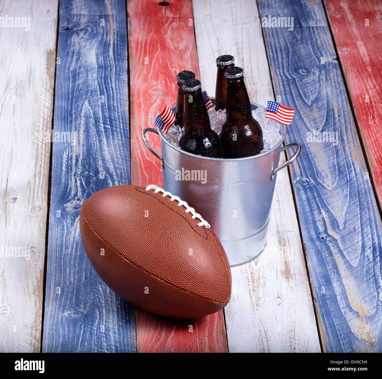 Draufsicht des American Football und Eimer eiskaltes Bier auf rustikalen Holztafeln gemalt in USA Nationalfarben. Stockfoto