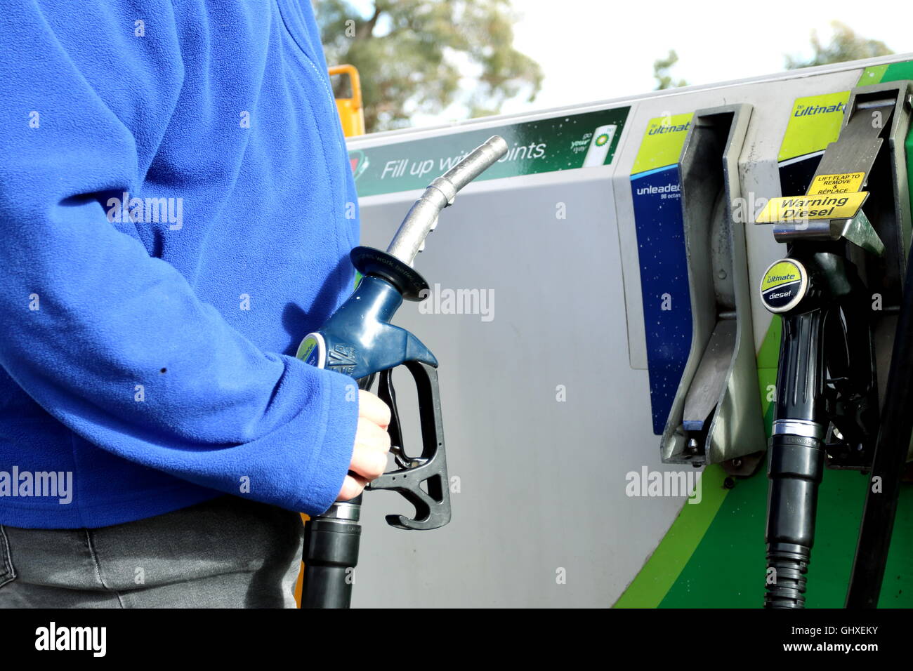 Männlichen Erwachsenen tanken Benzin bei BP - British Petroleum Zapfsäule in Melbourne Victoria Australien Stockfoto