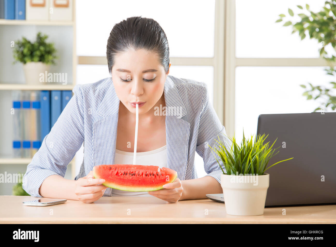 zuversichtlich Geschäftsfrau genießen die Wassermelonensaft von echtem Obst im Büro Stockfoto