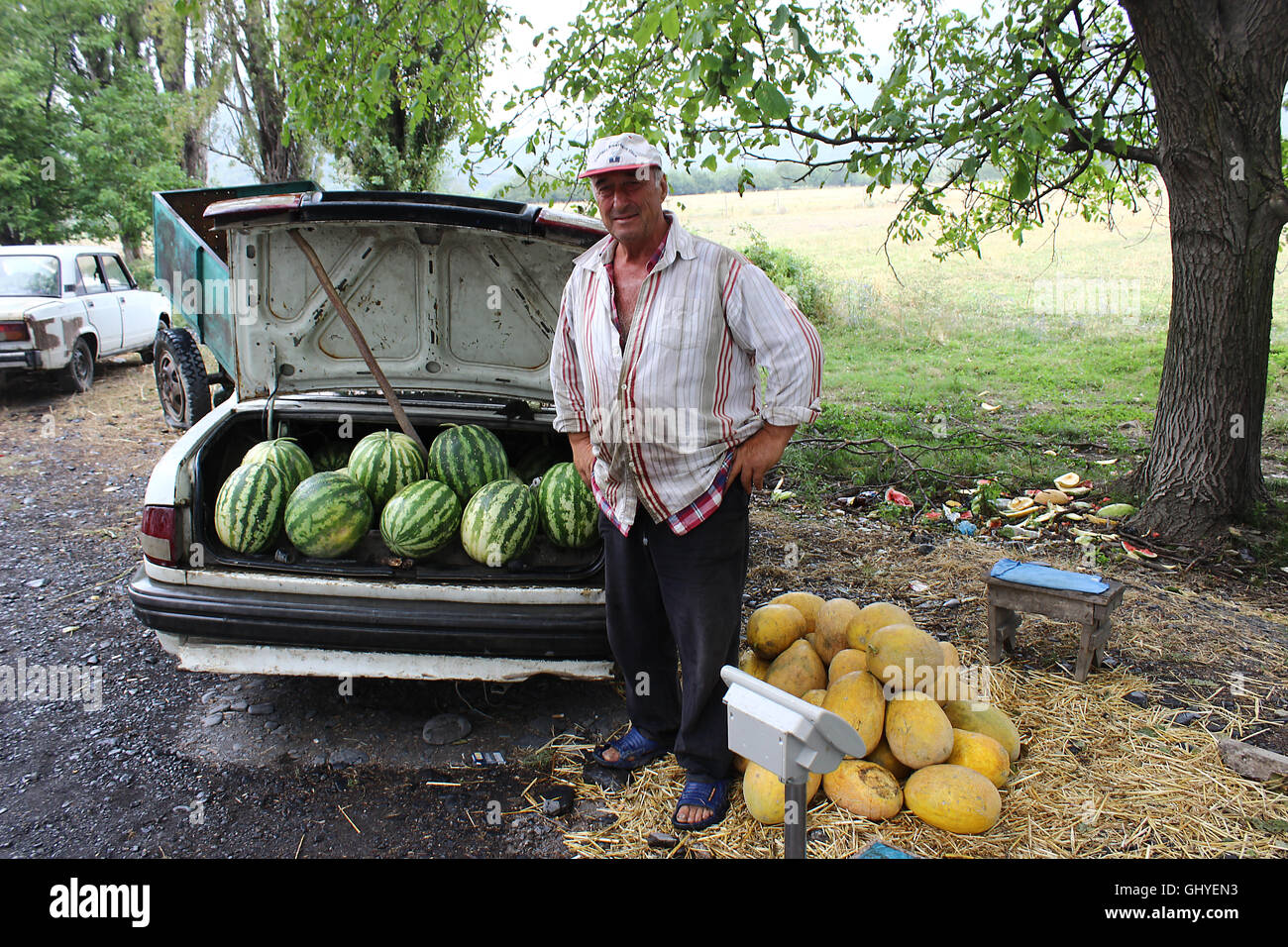 Obst-Verkäufer mit Rockmelons (Melone) und Wassermelonen neben Auto am Straßenrand. Reiseziel der Republik Georgien Stockfoto