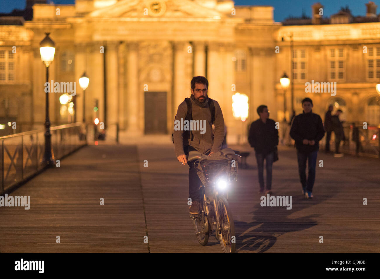 Figuren und Radfahrer auf der Pont des Arts in der Abenddämmerung, Paris, Frankreich Stockfoto