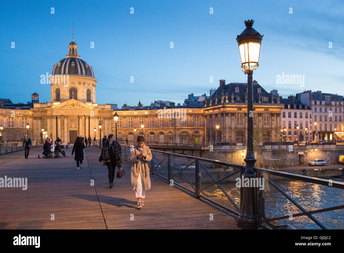 Menschen zu Fuß auf der Pont des Arts in der Abenddämmerung, Paris, Frankreich Stockfoto