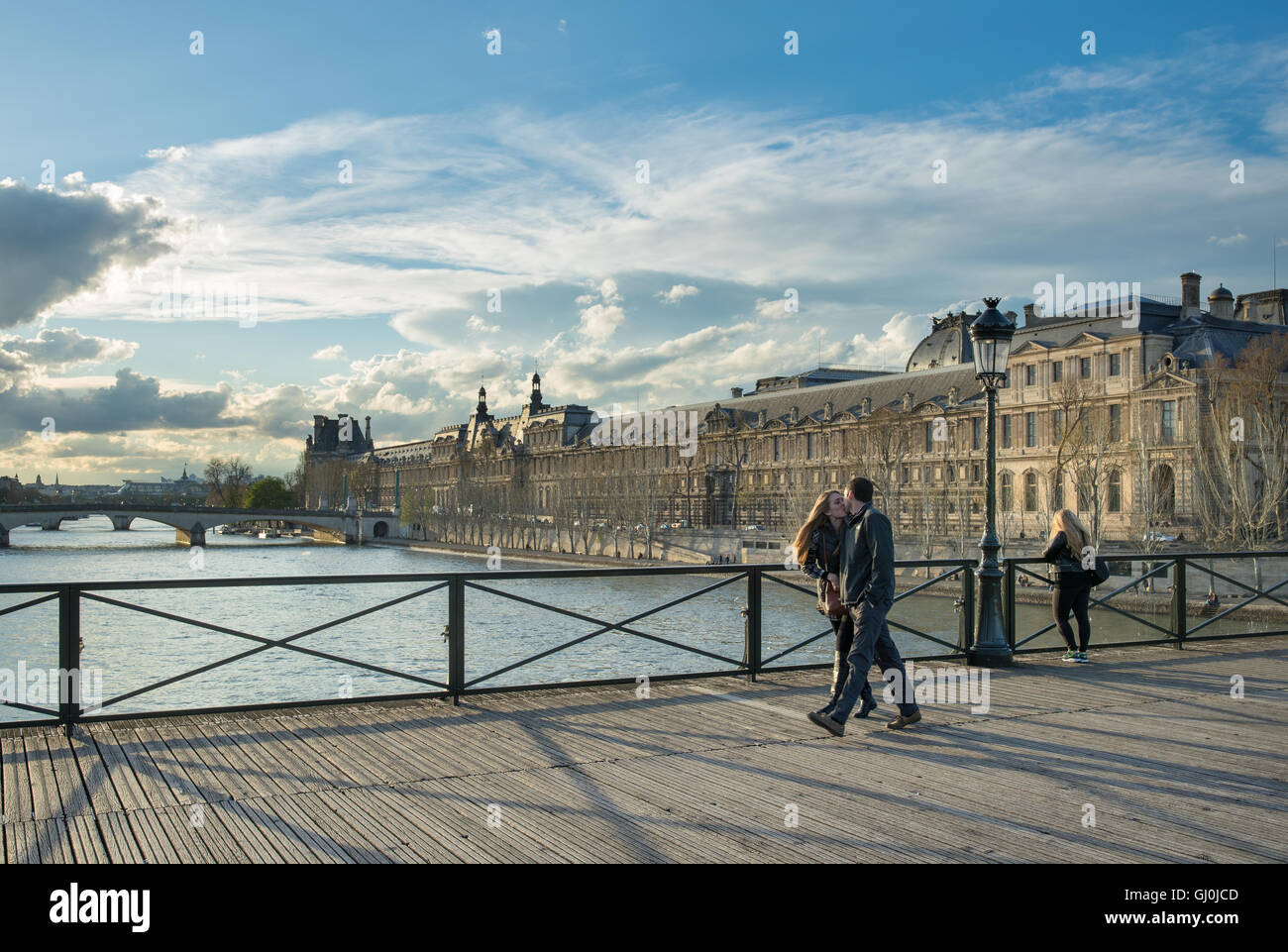 ein paar Küsse auf der Pont des Arts über den Fluss Seine mit dem Palais du Louvre, Paris, Frankreich Stockfoto