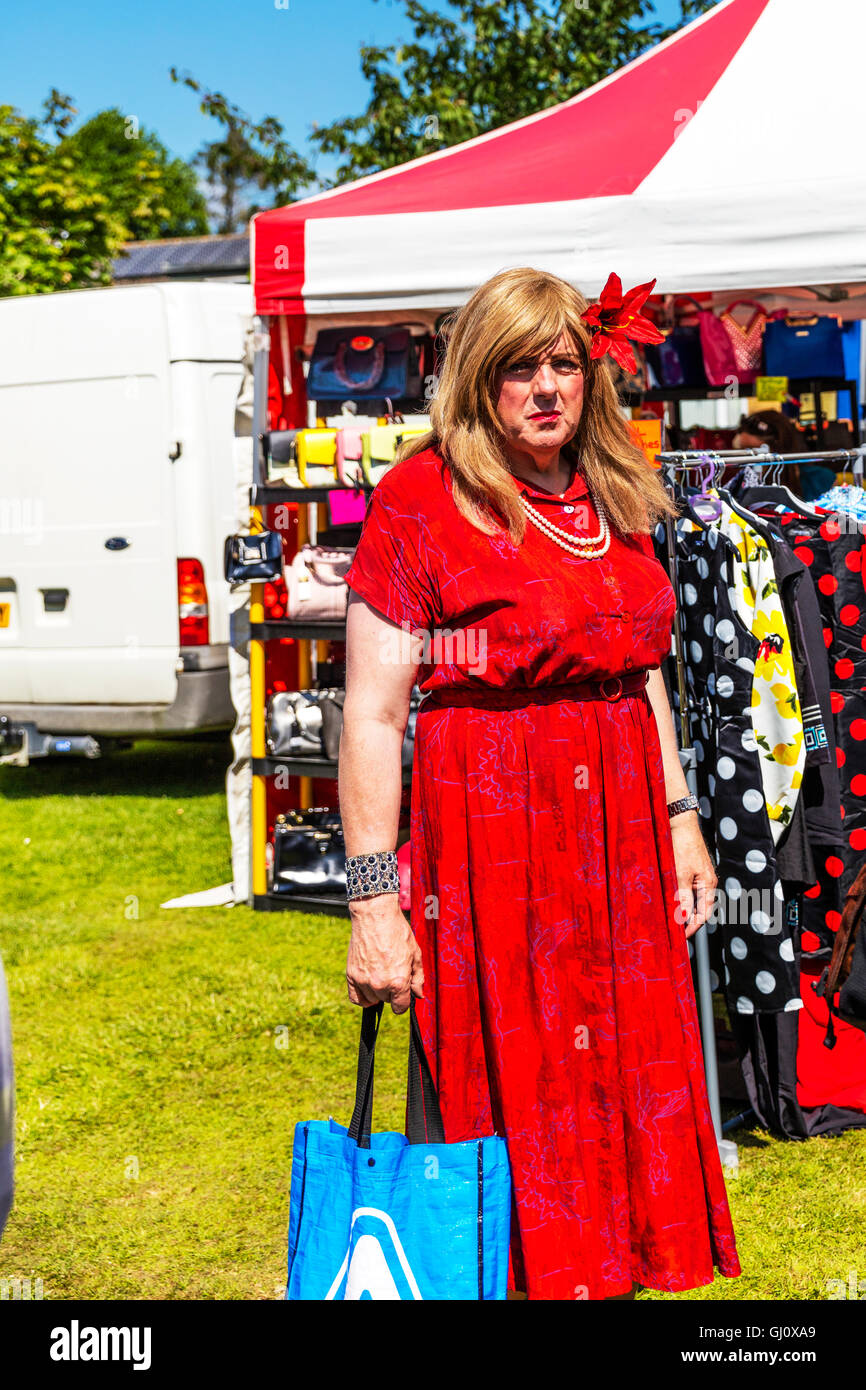 Transvestiten Mann in ein Transgender männliche Kleid rot Kleid Langhaar Perücke versucht