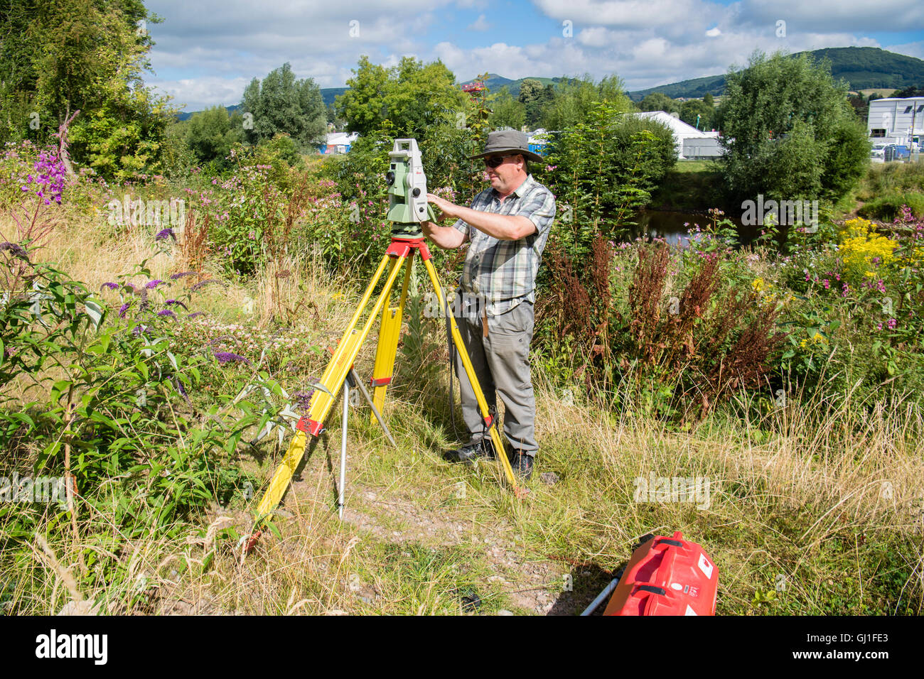 Einen professionellen Gutachter mit Leica Opti-Cal digital Theodolit Land Umfrage und Präzision Messinstrument auf einem Stativ, Mesaure die Menge an Boden und Land-Bewegung in der Nähe einer Wohnsiedlung in Abergavenny, Wales UK Monmouthsire Stockfoto