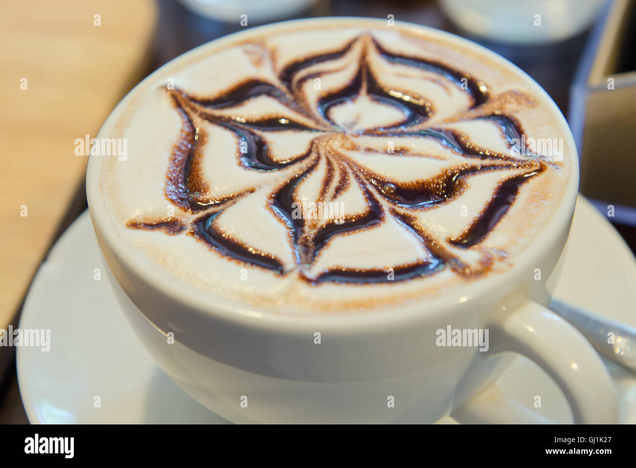 Latte Art Kaffee oder heiße Schokolade auf dem Tisch morgens Stockfoto