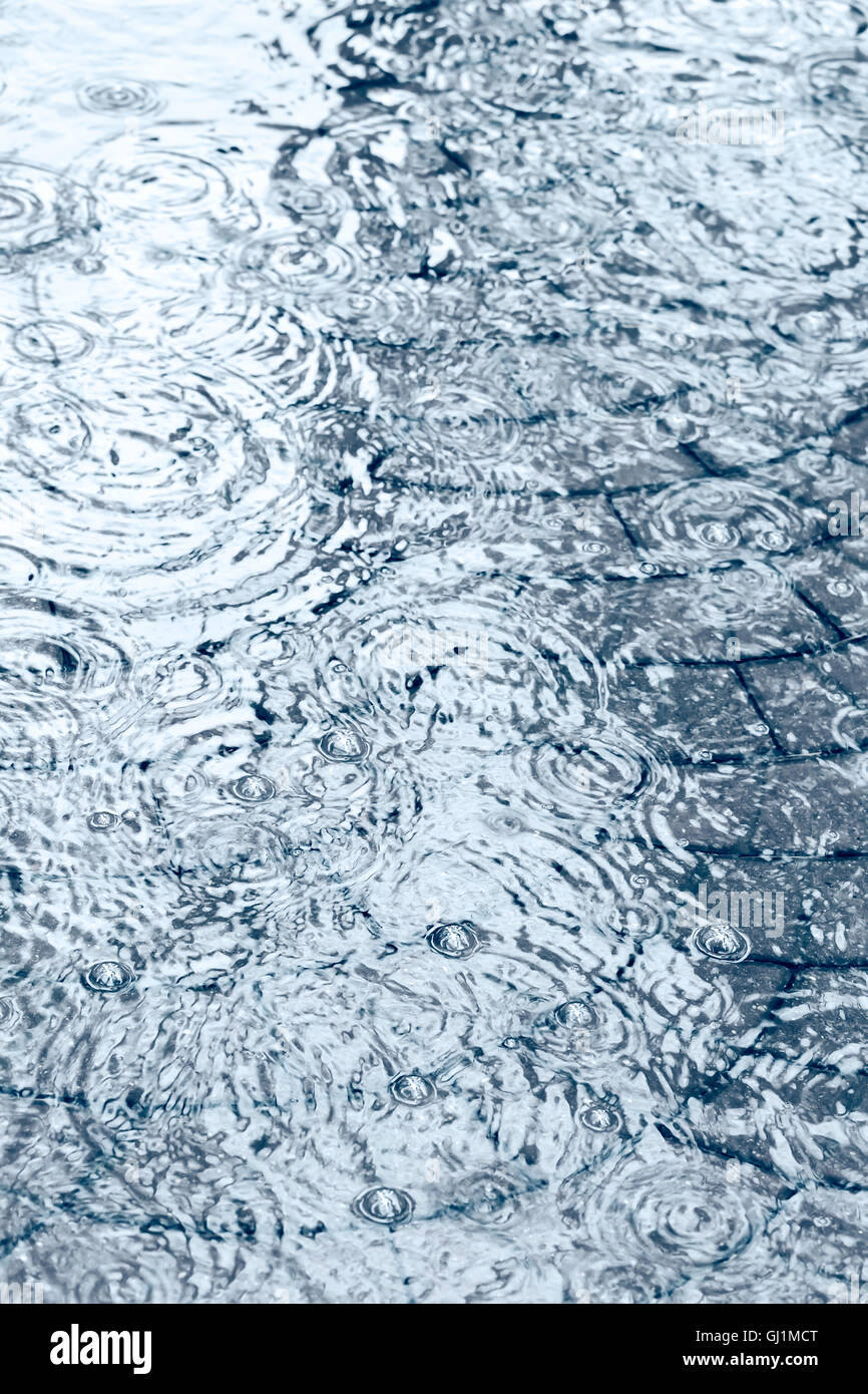 Wasser Pfütze auf Kopfsteinpflaster bei starkem Regen Stockfoto