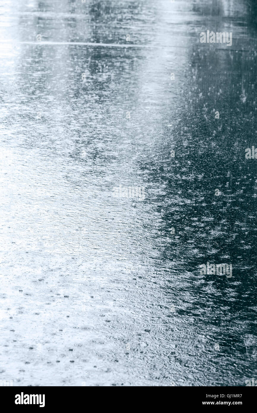 nassem Asphalt mit Regentropfen in einer Pfütze und Reflexionen Stockfoto