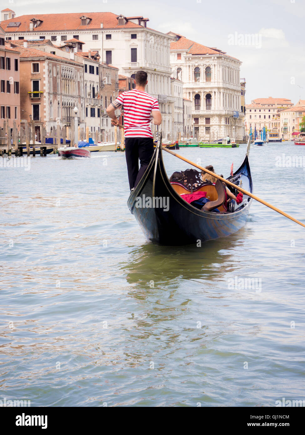 Gondel über den Canale Grande mit Gondoliere, einem traditionellen gestreiften Oberteil tragen. Venedig. Italien. Stockfoto