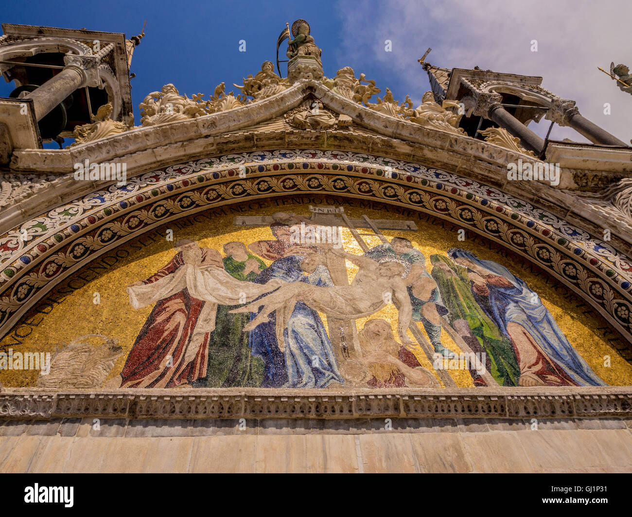 Kunstvolle Steinschnitzerei und Mosaikarbeiten einer der fünf Lünetten an der Außenseite der Markusbasilika in Venedig, Italien. Stockfoto