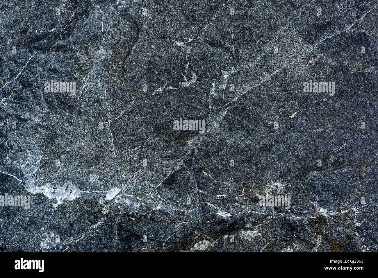 Muster und Textur in Nahaufnahme von fein gemasertem Eruptivgestein mit Quarz Intrusionen Stockfoto