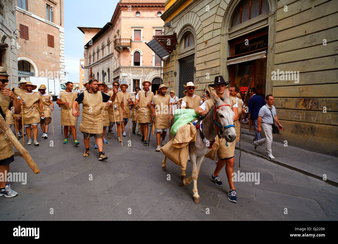 Mitglieder des Siegerteams La Lupa von Julys Il Palio-Pferderennen, Wandern mit einem Esel in Siena, Italien Stockfoto