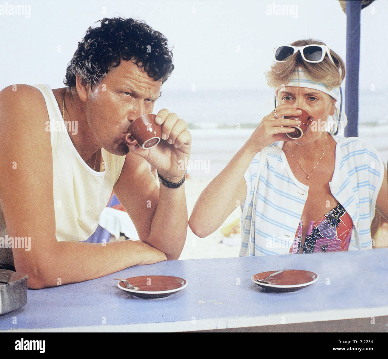 MAN SPRICHT DEUTSCH BRD 1987 - Hanns Christian Müller Familie Löffler - Mehr Oder Minder - Genießt Den Letzten Urlaubstang eine der Adria. Szene: Erwin (GERHARD POLT) Und Irmgard (GISELA SCHNEEBERGER) Trinken Den dt. Expresso bin Strang. Daheim Gibt Dann Vergütungspolitik Wieder Filterkaffee. Regie: Hanns Christian Müller Stockfoto