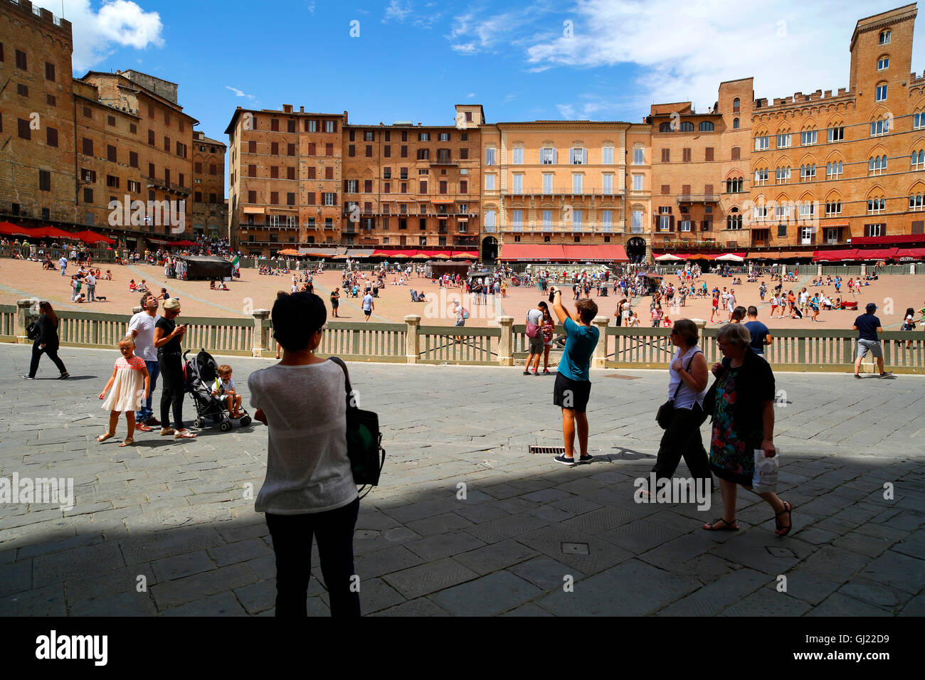 Touristen auf der Piazza del Campo, berühmt für das Il Palio-Pferderennen in Siena, Italien Stockfoto