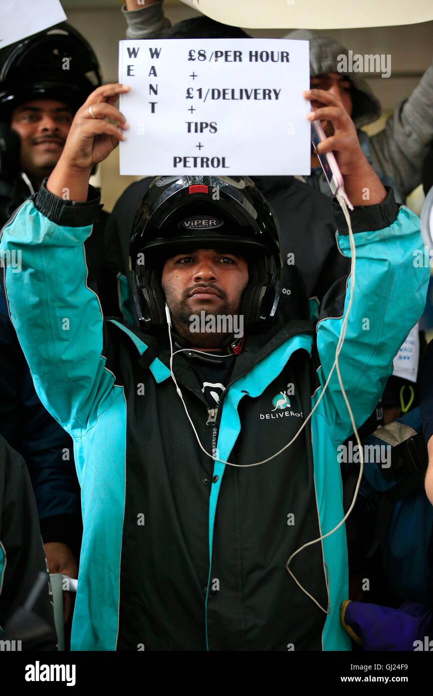 Ein Deliveroo Fahrer hält ein Schild während einer Protestaktion außerhalb des Unternehmens HQ in Torrington Place, London. Stockfoto