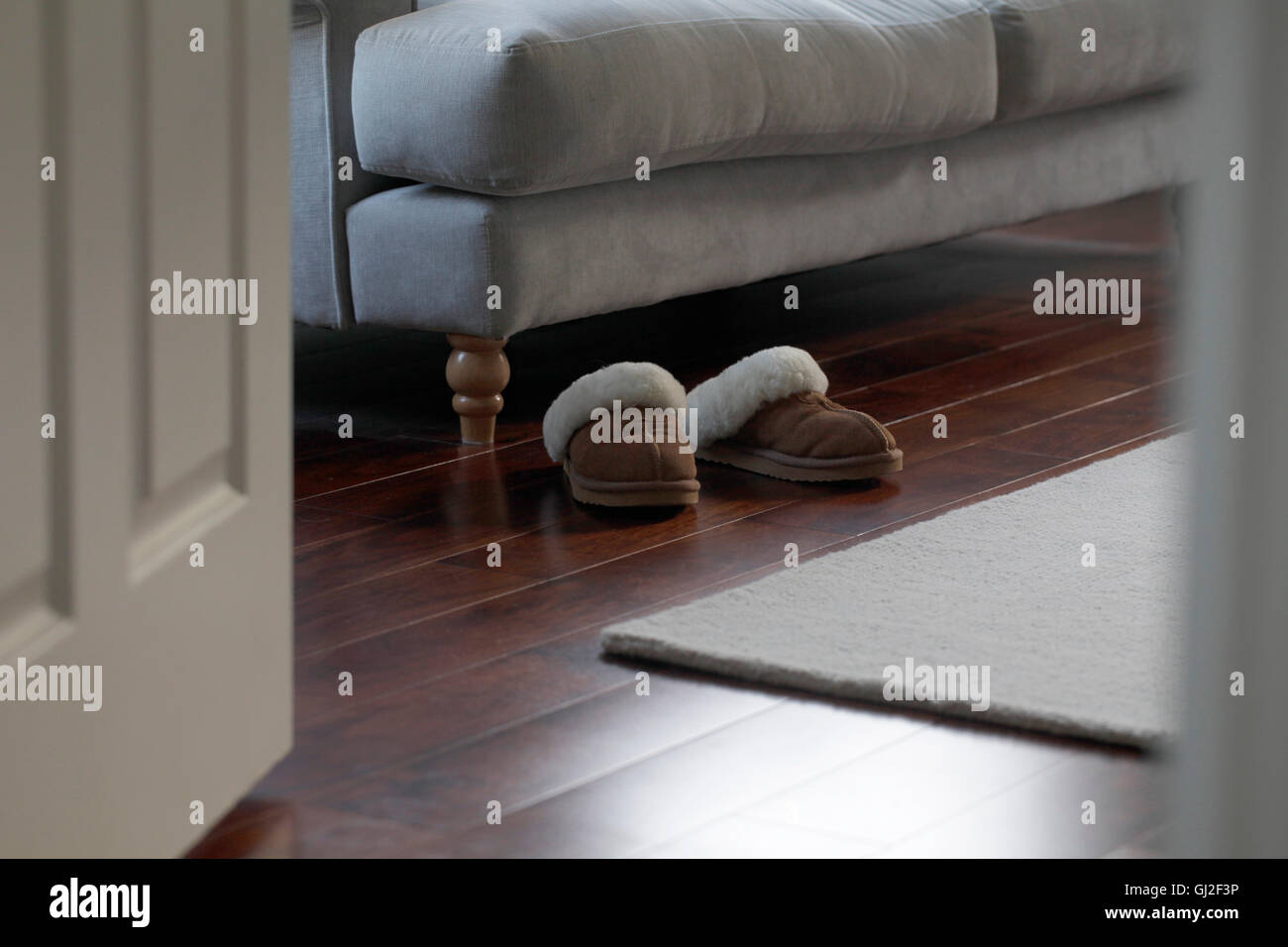 Schuhe auf den Boden neben couch Stockfoto