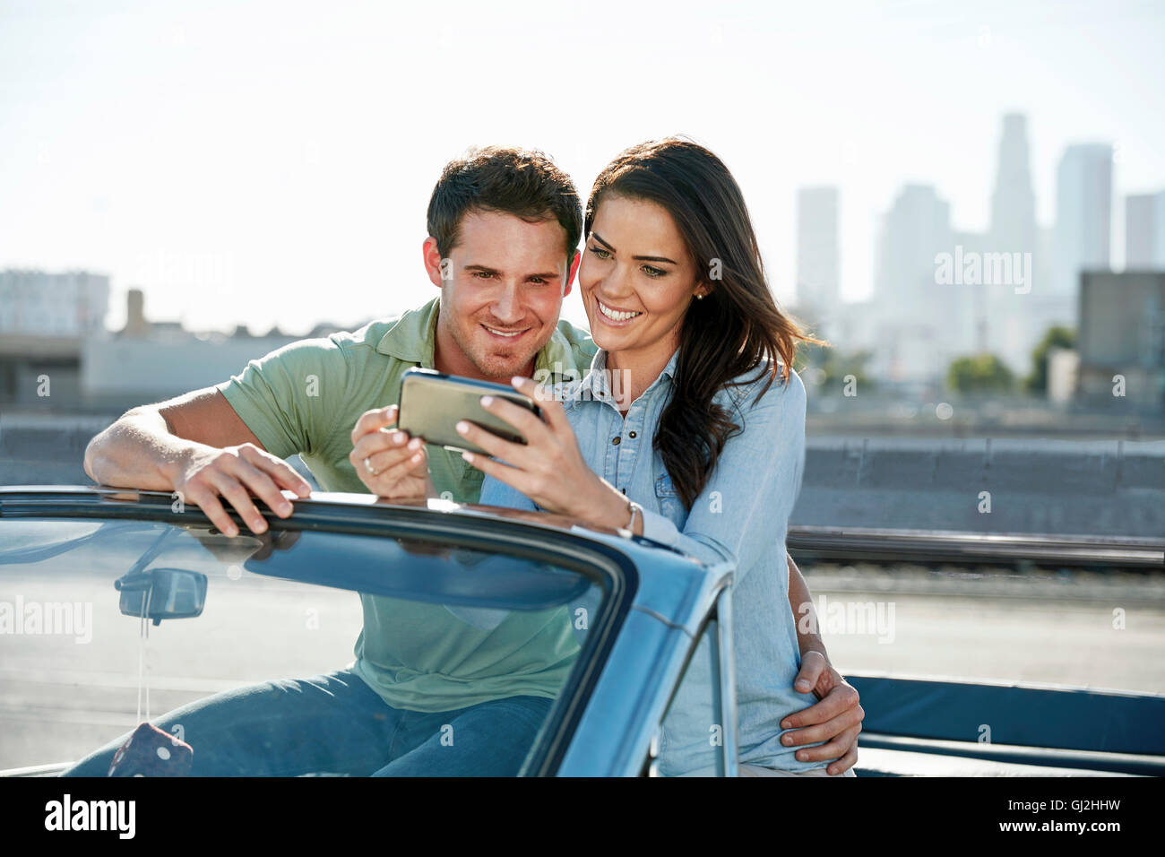 Paar im Cabrio Blick auf Smartphone, Los Angeles, Kalifornien, USA Stockfoto