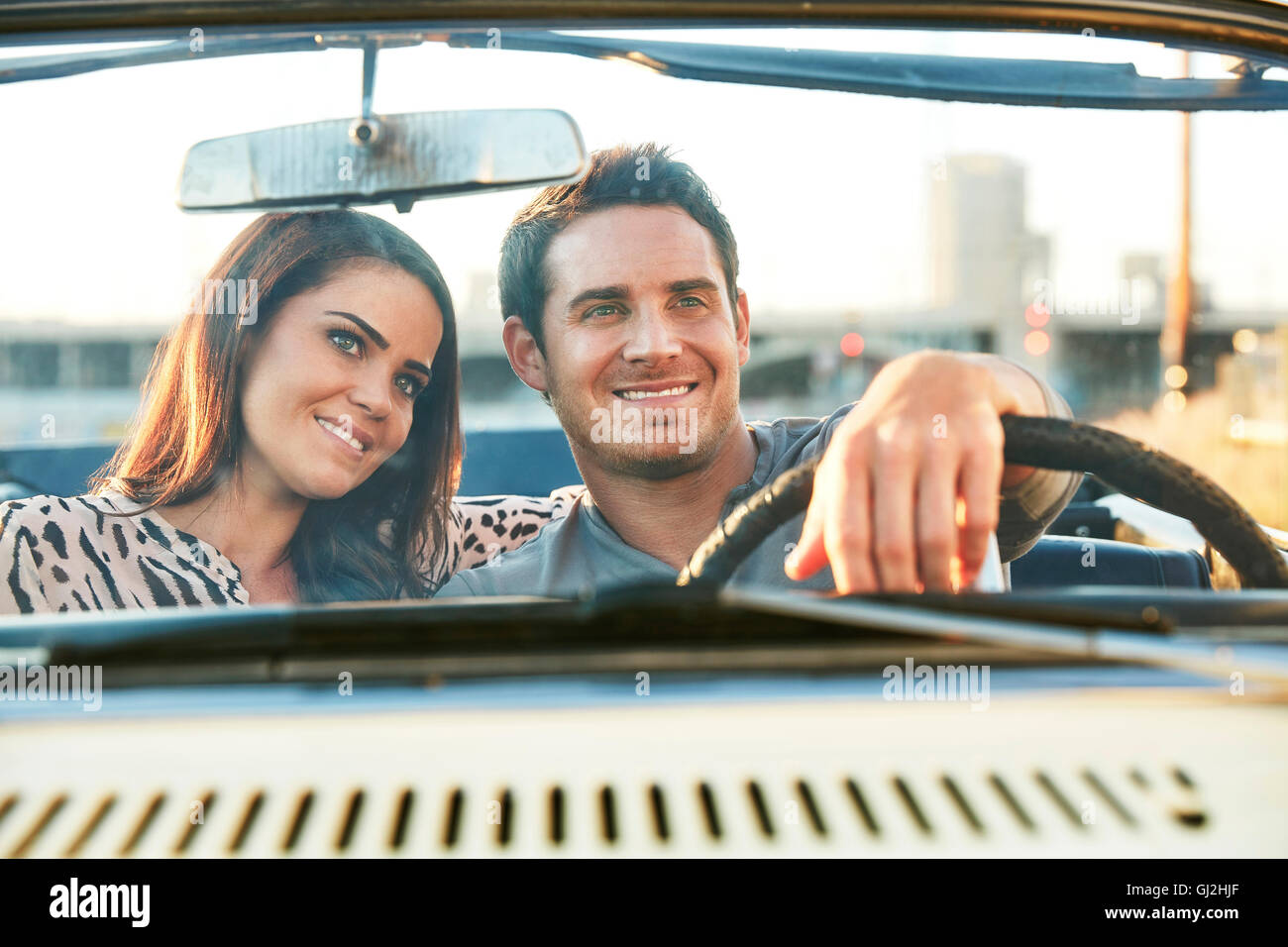 Blick durch die Windschutzscheibe des Paares im Cabrio lächelnd, Los Angeles, Kalifornien, USA Stockfoto