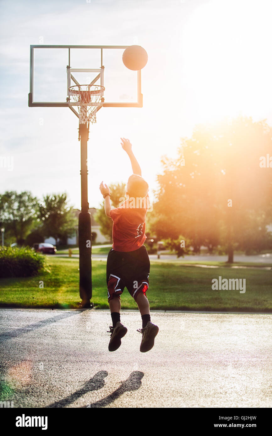 Kleiner Junge schießen Basketball Sprungwurf Stockfoto