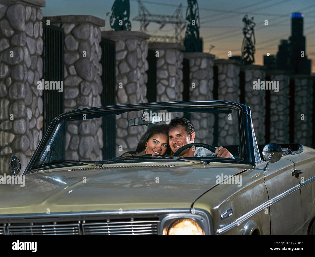 Paar im Cabrio in der Abenddämmerung Stockfoto
