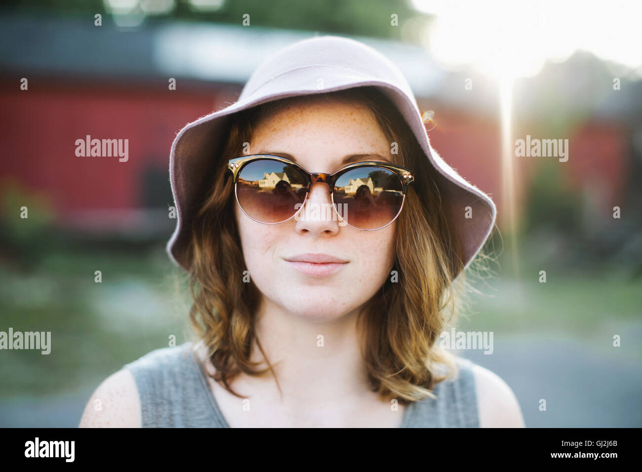 Frau mit Sonnenbrille und Sonnenhut Blick in die Kamera Stockfoto