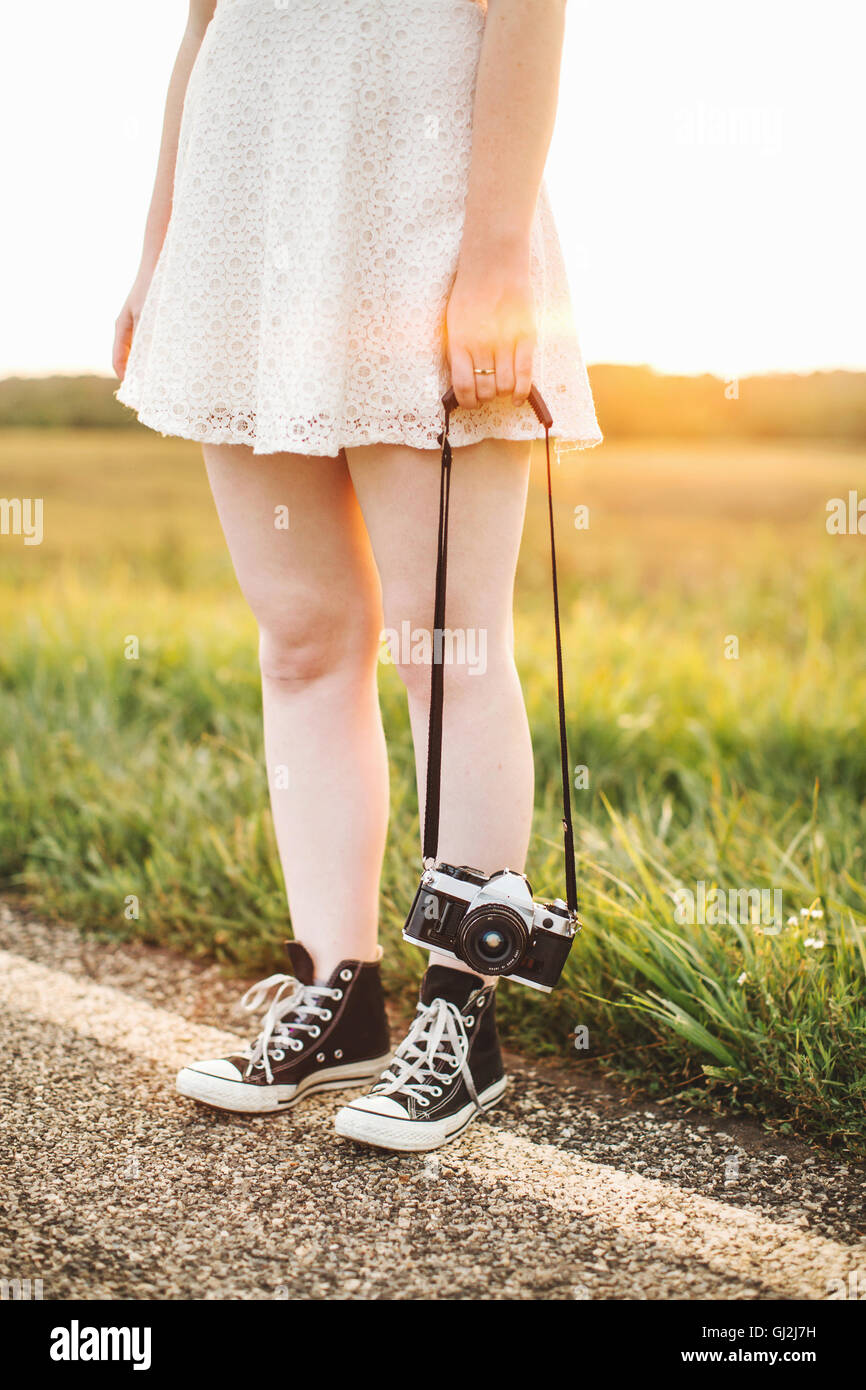 Taille abwärts Frau mit Kamera am Straßenrand Stockfoto