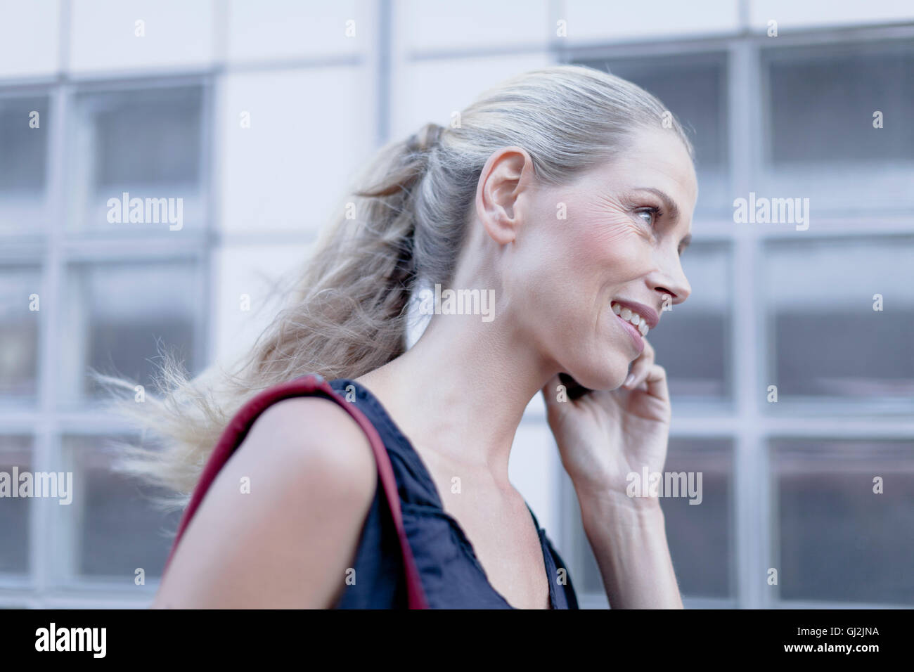 Reife Frau, walking im Freien, mit smartphone Stockfoto