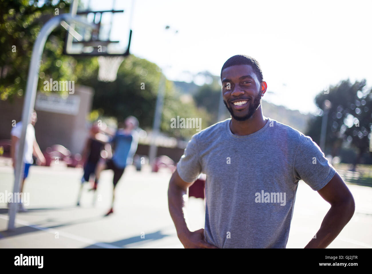Porträt des jungen Mannes am Basketballplatz Stockfoto
