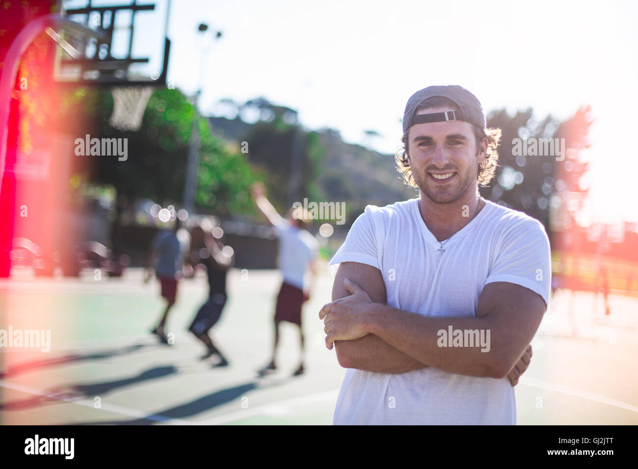 Porträt des jungen Mannes am Basketballplatz Stockfoto